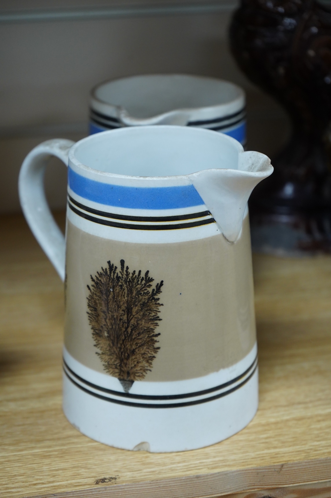 Three early 19th century Mocha ware jugs and a mug, largest 16cm high